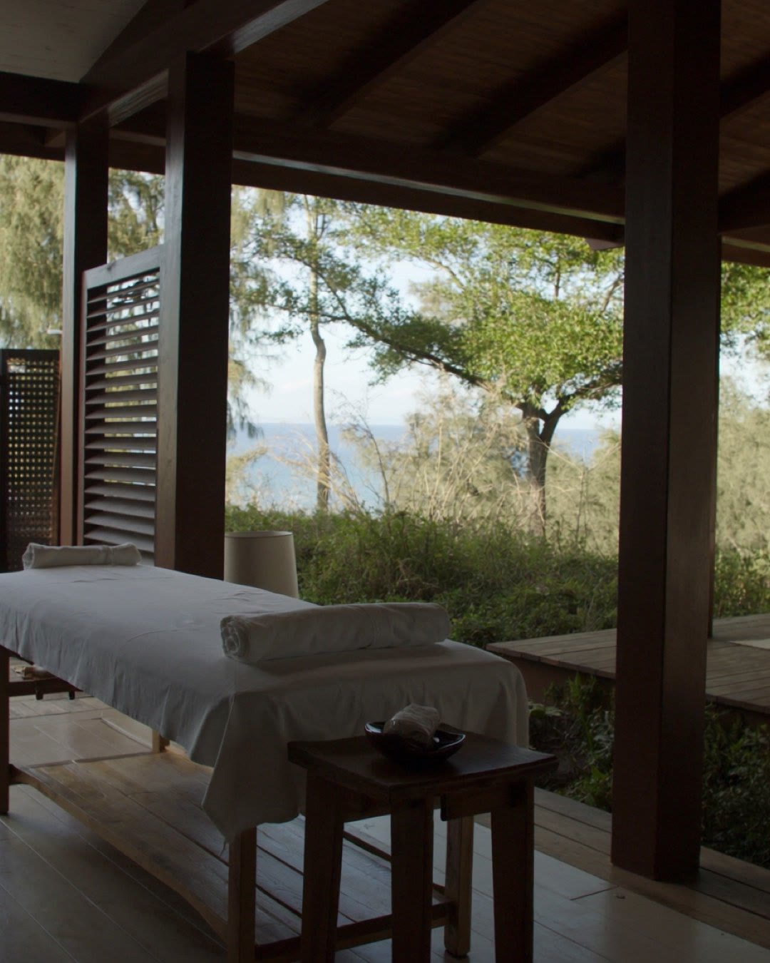A massage table on a deck looking out to the trees